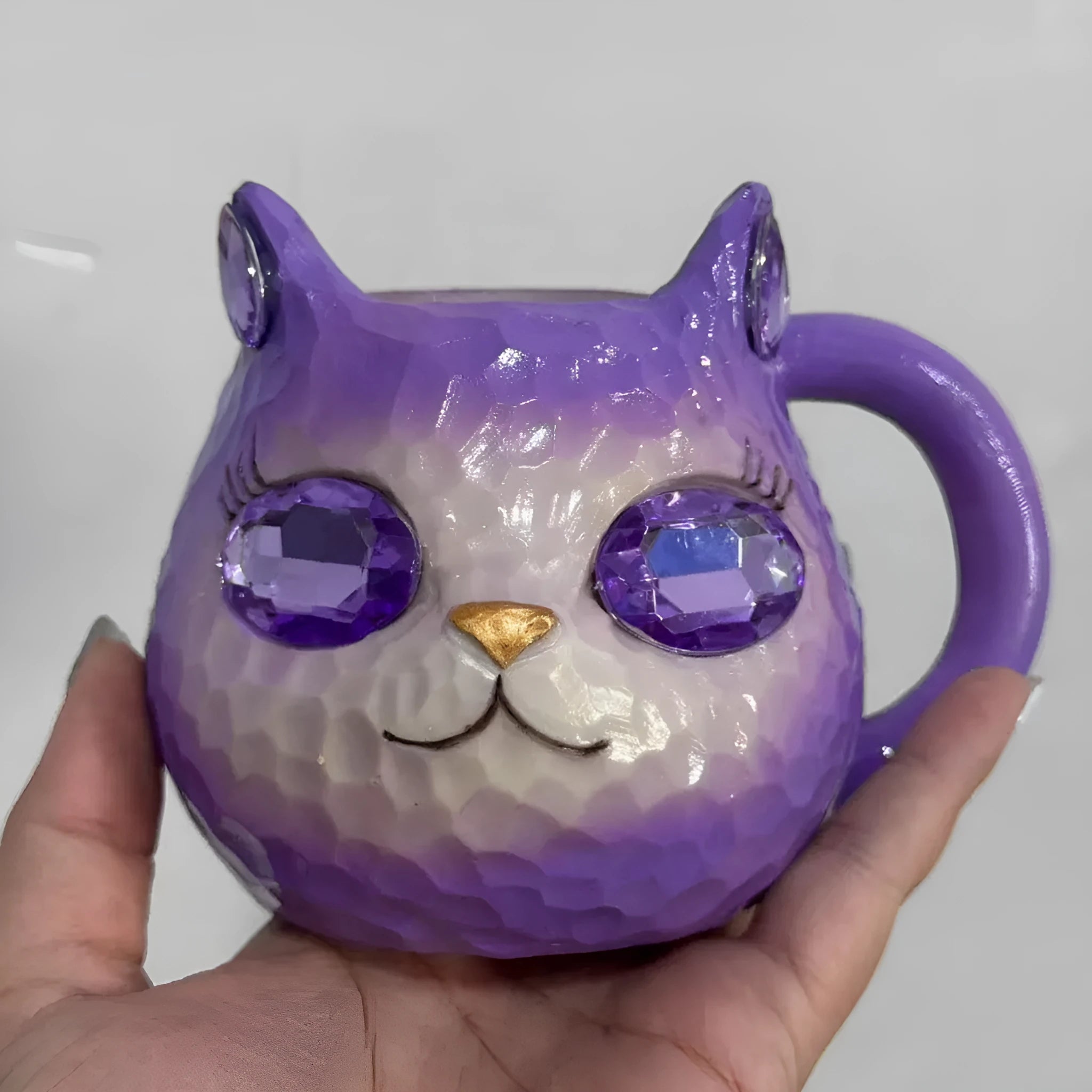 Resin cat cup ornament with crystal earth design in blue, green, pink, or purple colour options.