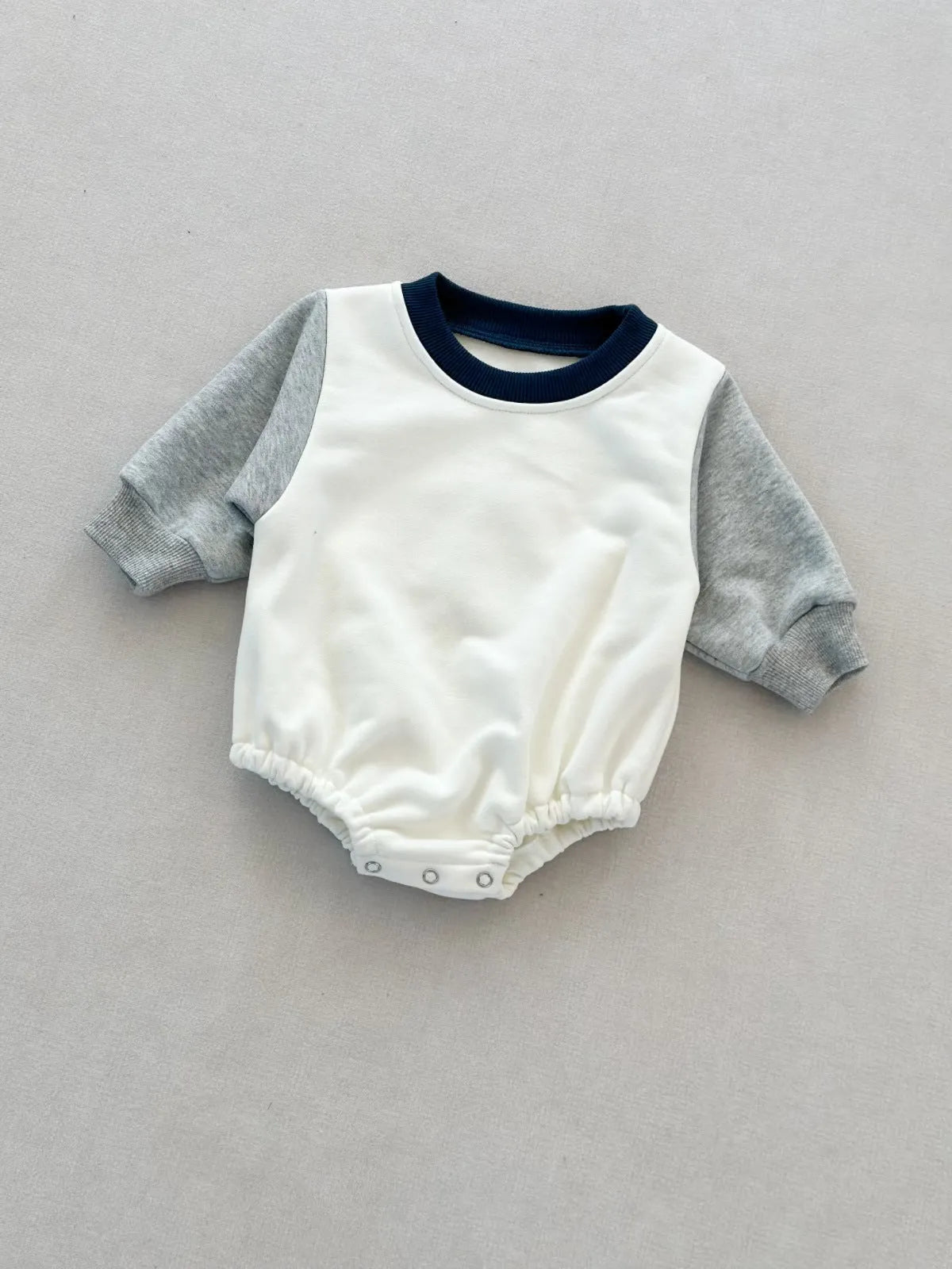 Baby romper in cotton triangle jumpsuit style with hidden hook closure, autumn weight, available in multiple colours