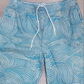 Man wearing loose fit straight leg shorts with a colourful 3D digital print design.
