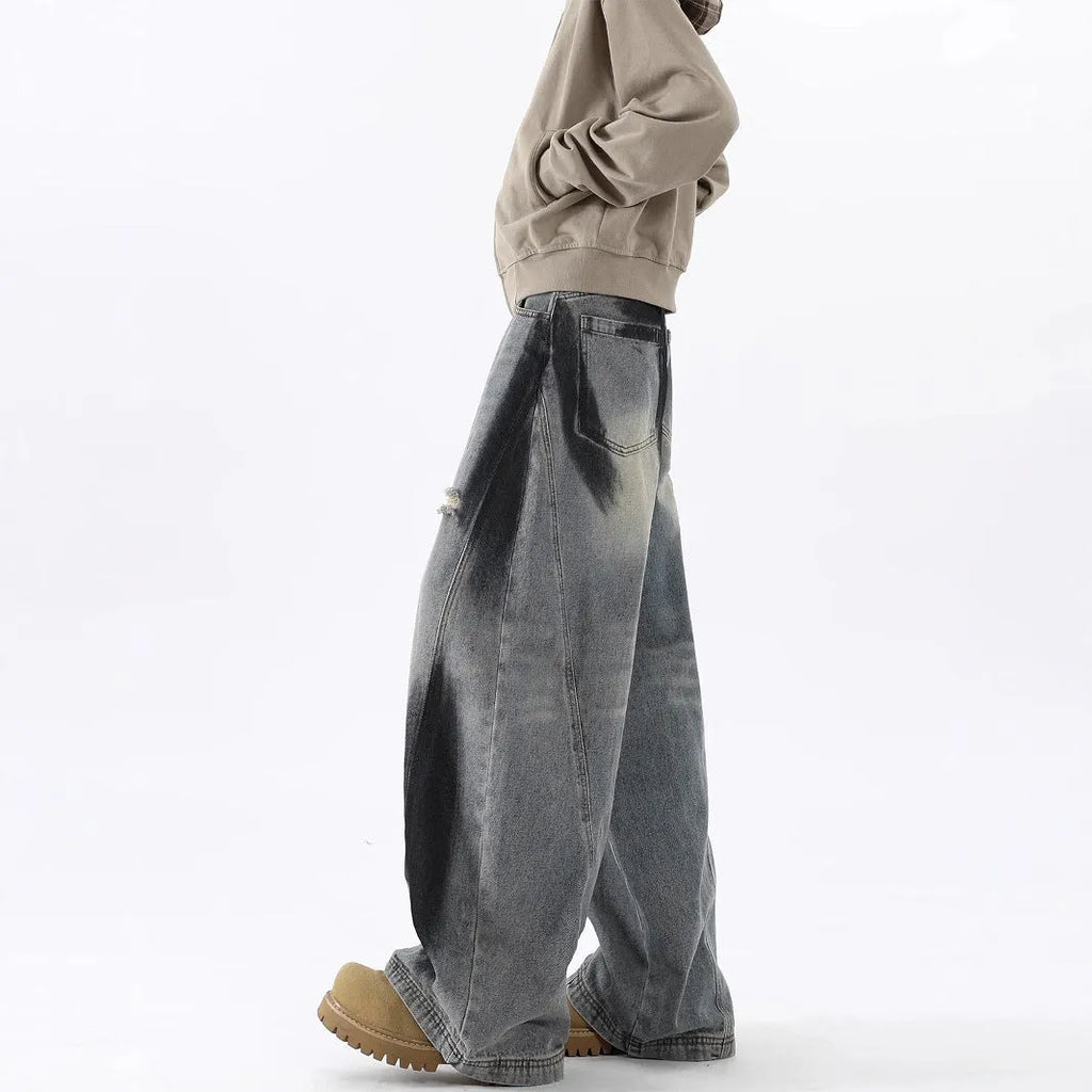 Blue men's loose fit jeans featuring a splash-ink pattern and ripped knee detailing.