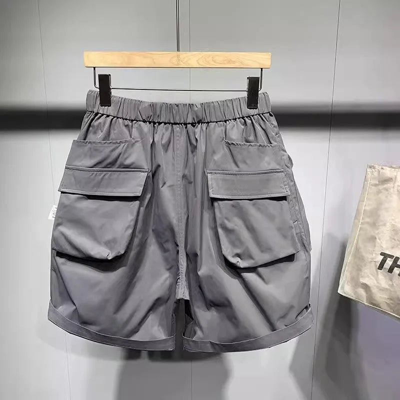 Men's black loose-fitting work shorts with elastic waistband and pockets, laid flat