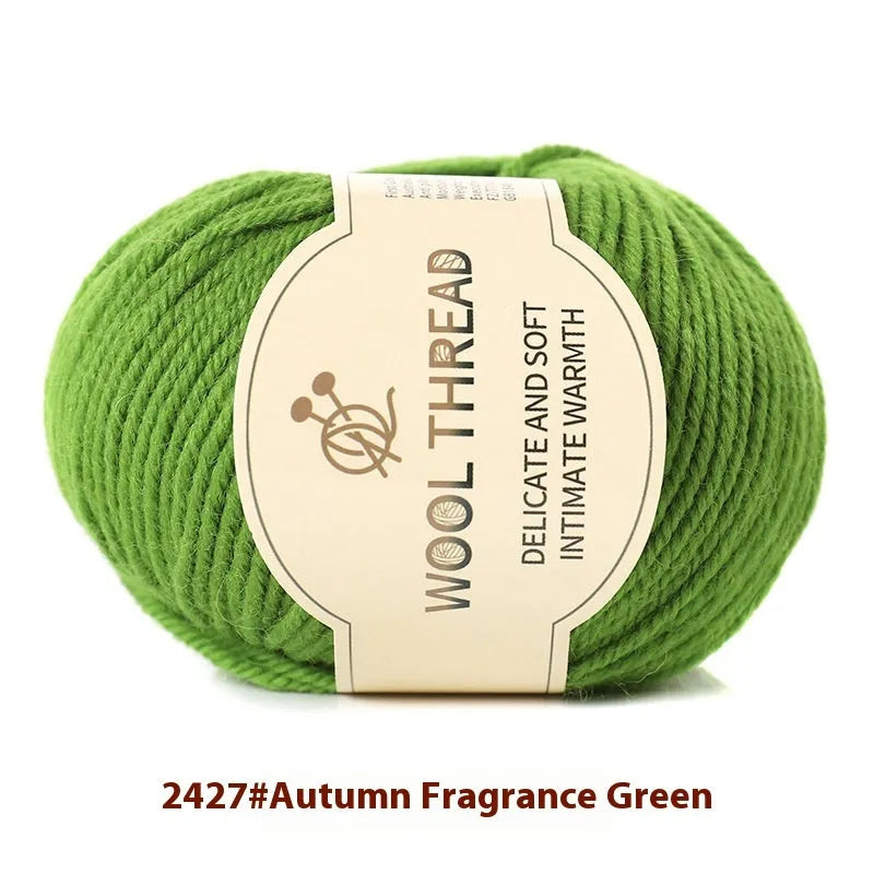 One roll of beige domestic wool hand-knitting yarn for size 10 needles next to knitting needles.