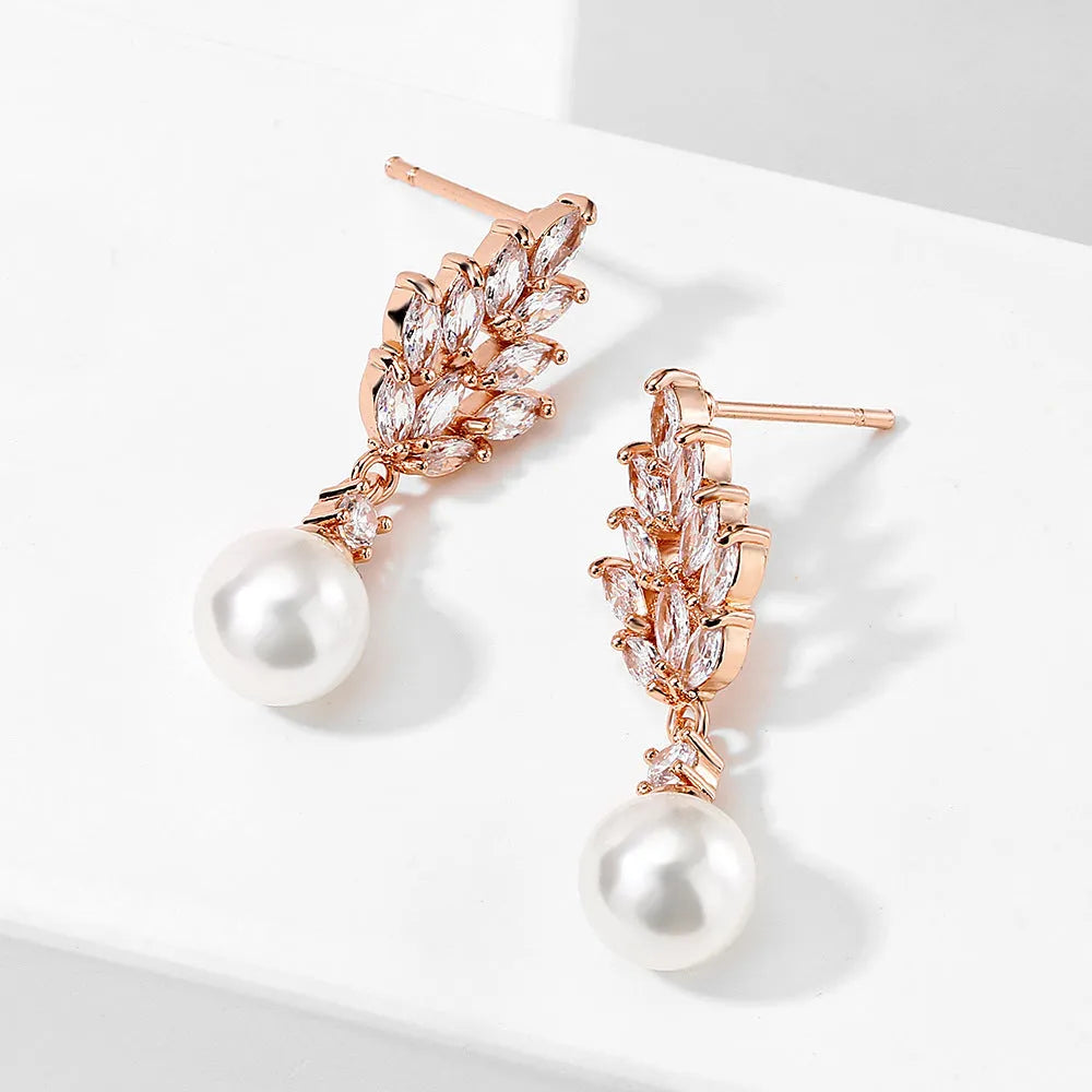Geometric flower-shaped earrings with micro inlaid zircon and pearl details on a gold-toned metal base.