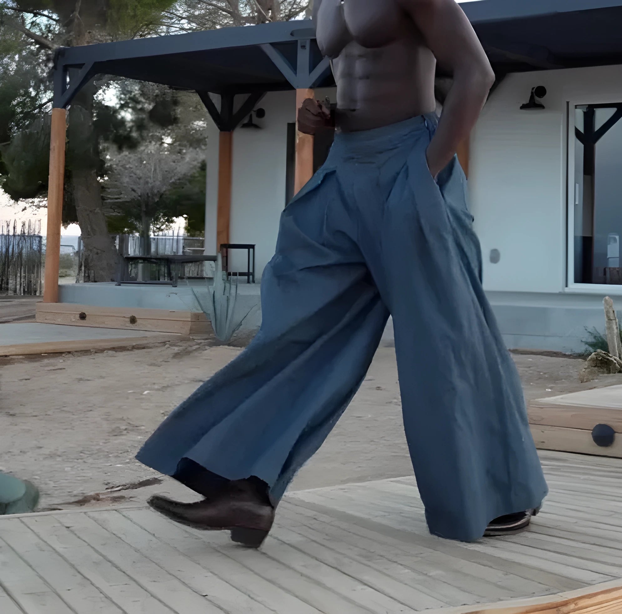 Men's grey pleated wide-leg trousers with an elasticated back waistband on a hanger.