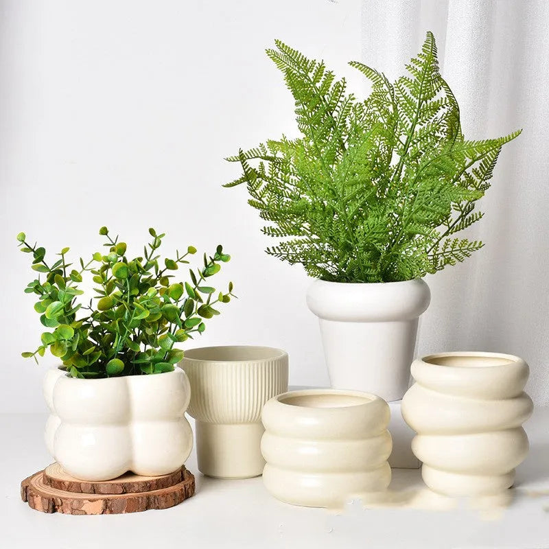 Roman column matte yellow ceramic flower pot on a table.