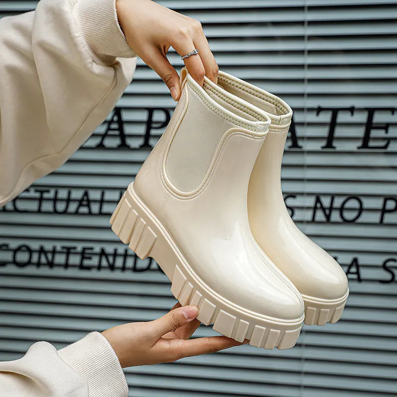 A pair of low tube, flat-heeled PVC rain boots in a solid colour.