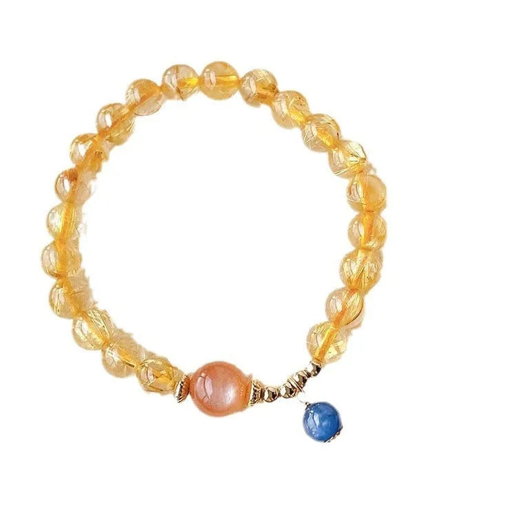 Gold rutilated quartz and sunstone bracelet with round diamond-shaped beads.