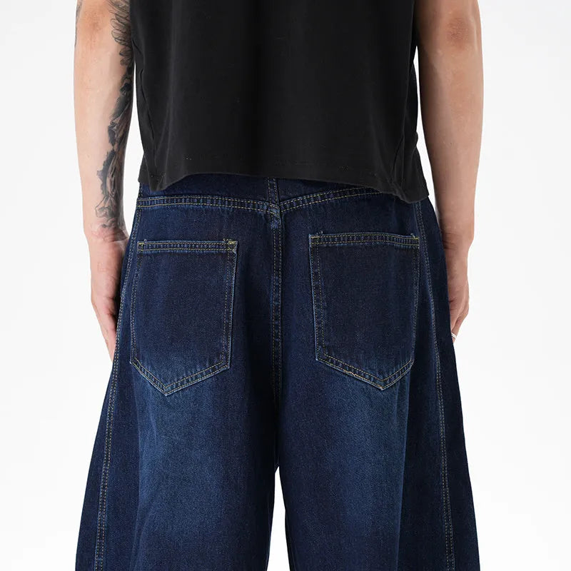 Dark blue washed distressed wide leg machete jeans showing denim fabric texture and wide leg silhouette