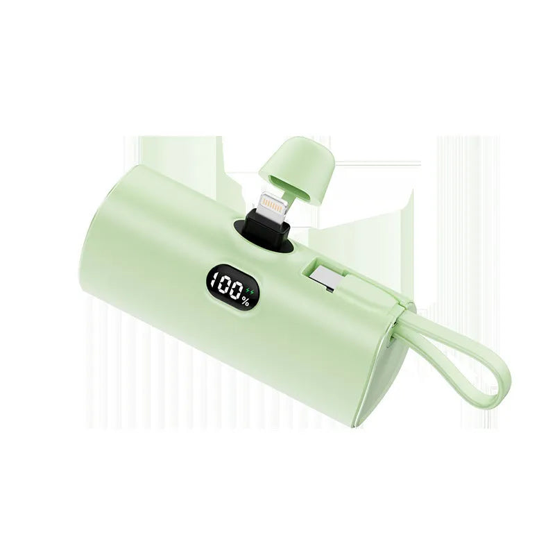 Colourful capsule-shaped power bank with digital display and a folding plug extended.