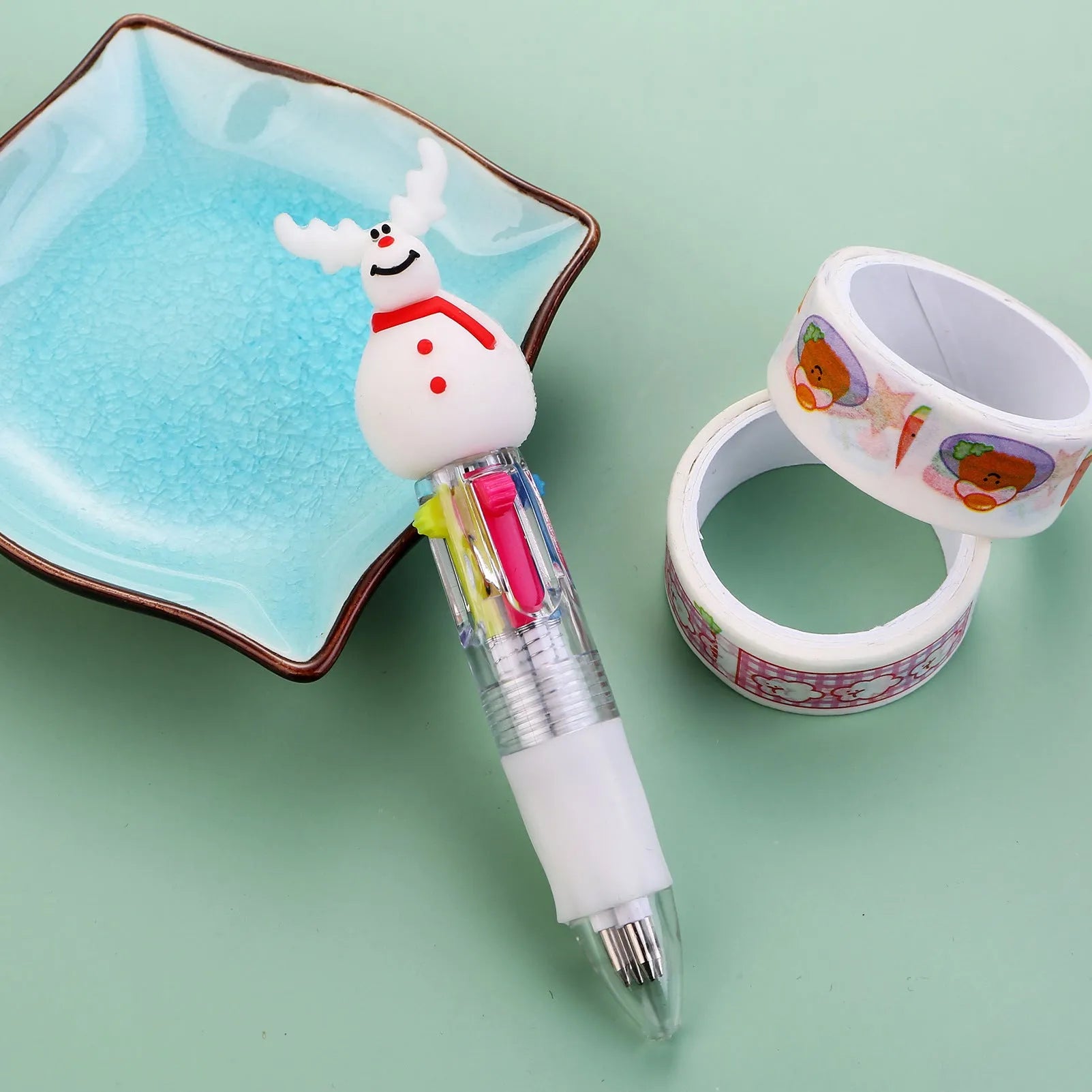 Compact 11cm Christmas ballpoint pen with four colours and festive designs like snowmen and reindeer.