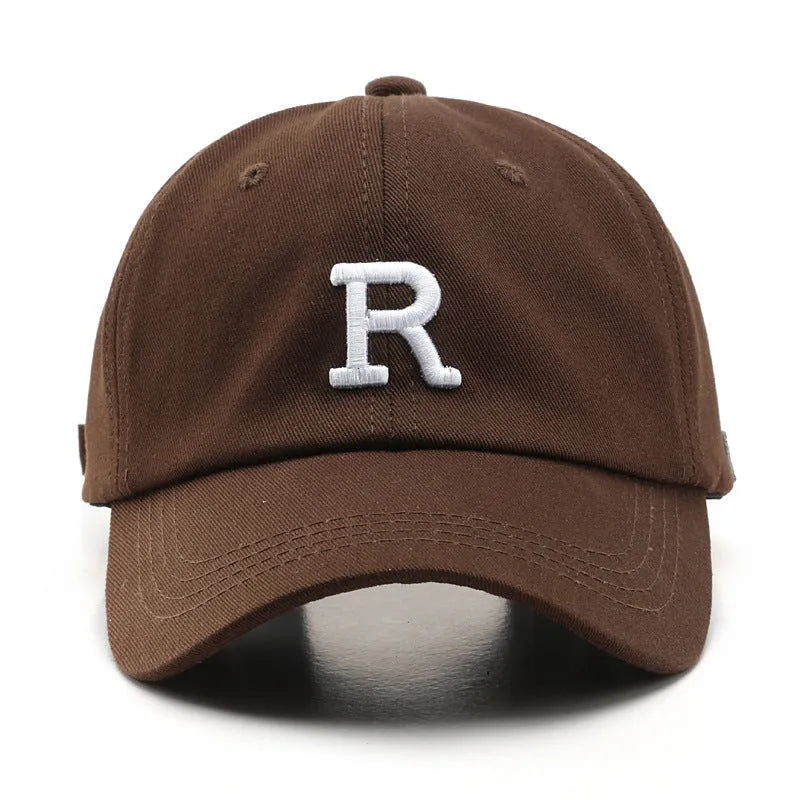 Adjustable cotton baseball cap with embroidered letter R in beige colour, dome style, unisex design