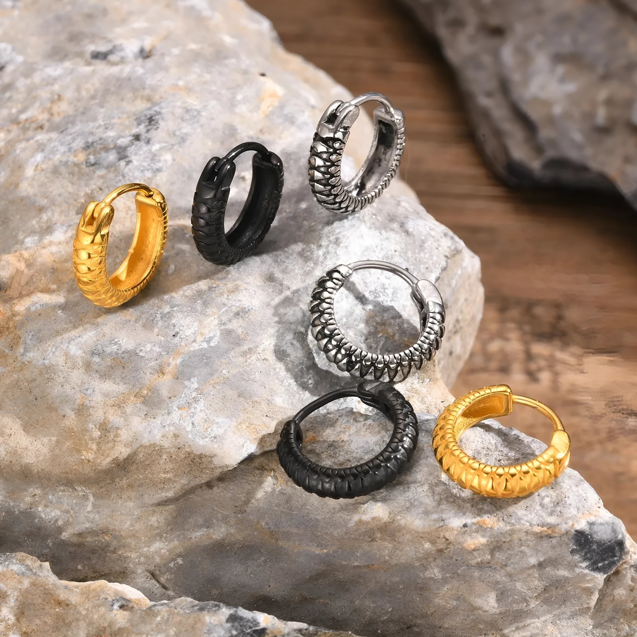 A pair of stainless steel stud earrings for men with a snake pattern, shown in black and gold colour options.
