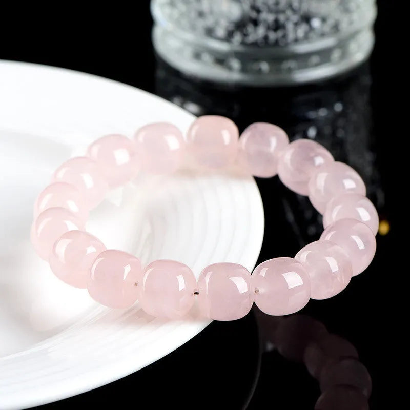 Pink natural bamboo crystal bracelet with geometric barrel beads on a wrist.