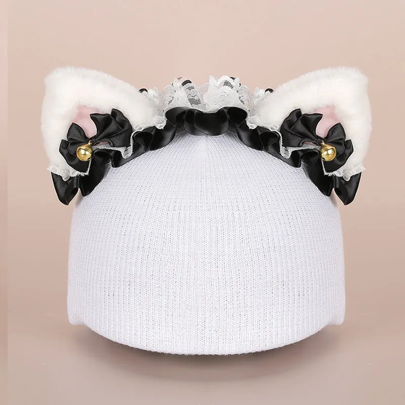 A plush fabric cartoon-themed decoration attached to the top of a blue ski helmet on a snowy slope.