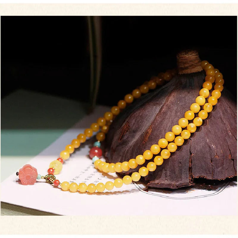 Close-up of a women's amber bracelet with animal modelling on round 5mm beads.