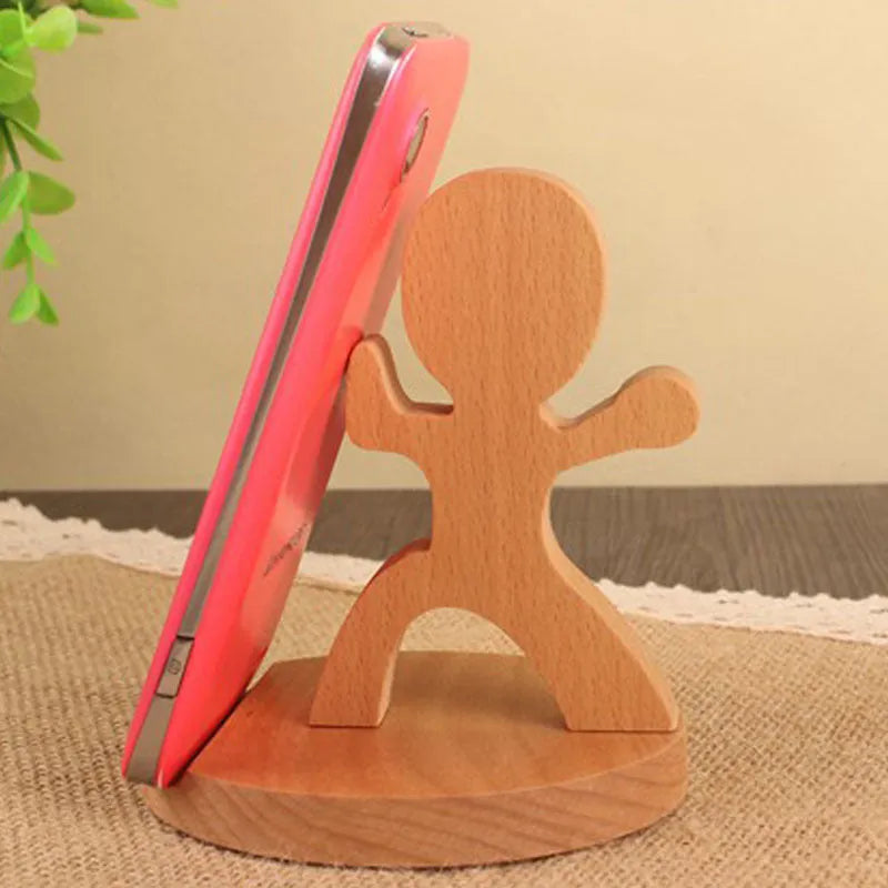 Sculpted beech wood lazy bracket phone holder with custom engraved text on a wooden desk.