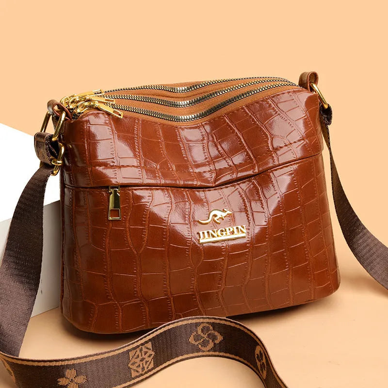 Brown cross body messenger bag with multiple compartments and sewing thread details on PU material