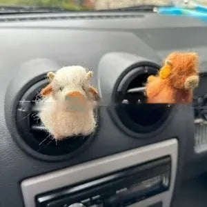 Scottish Highland Niutong air outlet clip in white plastic on a car dashboard vent