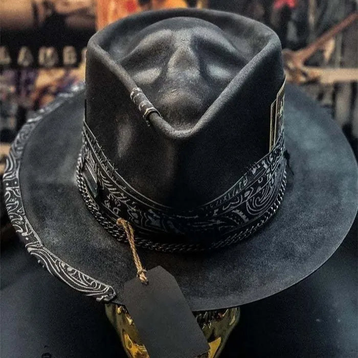 Handmade black wool felt skull hat with conical crown and blue denim accent band, shown from the side.
