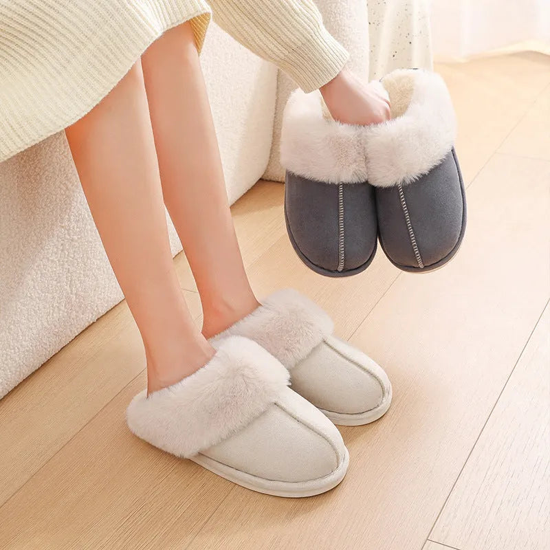 Women's brown plush indoor slippers with a round toe, flat heel, and stitching detail.