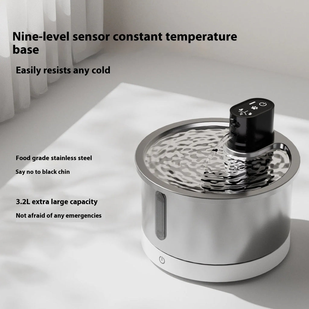 Stainless steel heated water fountain for cats and dogs on a white base.