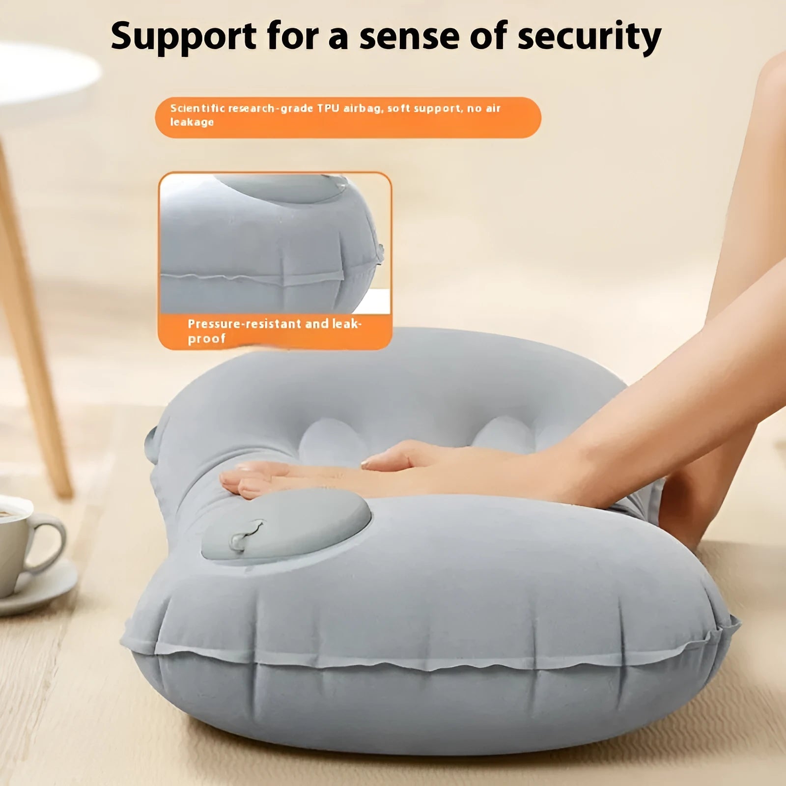 Grey inflatable travel pillow with soft flocking surface, shown deflated and next to a backpack for scale.