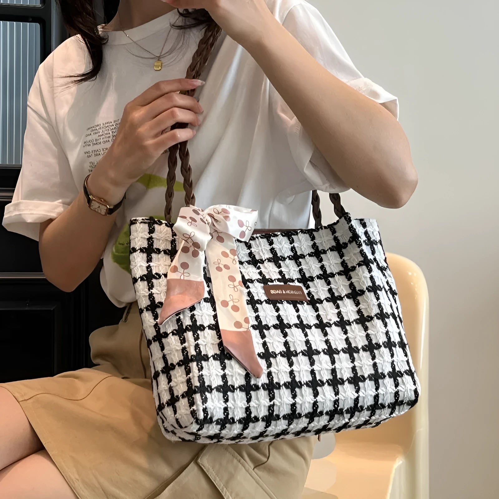 Black woven wool shoulder bag with horizontal square design and internal organisation compartments