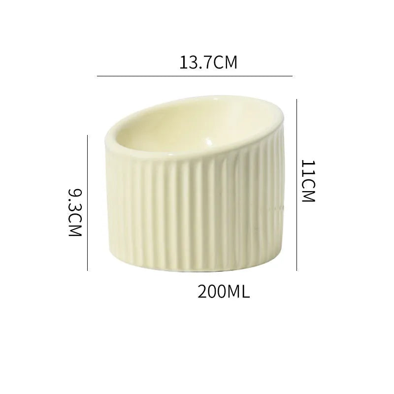 Ceramic elevated cat food bowl in green, showing tilted round dish on a raised stand.