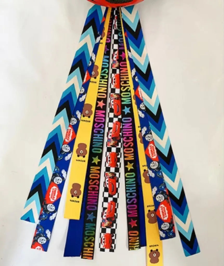 A decorative ribbon streamer for attaching to a child's roller skate or ski helmet, shown in a selection of colours.