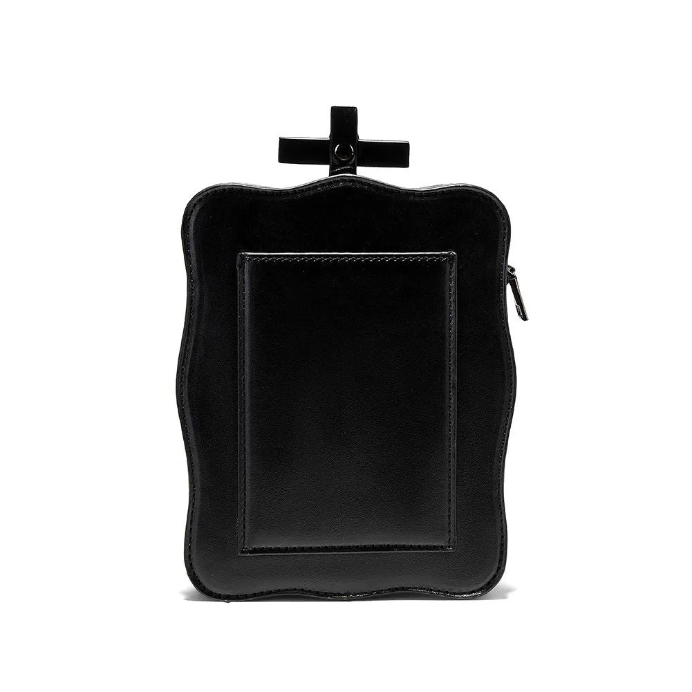 Black mini square crossbody bag with embossed skull design, metal chain strap, and zip closure.