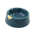 Green flower-shaped plastic double bowl for cat or small dog food and water on a plain surface.