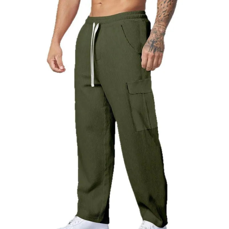 Man wearing navy blue loose-fit corduroy cargo trousers with a drawstring waist.