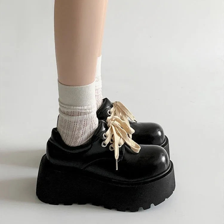 Matte black women's lace-up ankle boots with a chunky rubber sole and a thick English muffin heel.