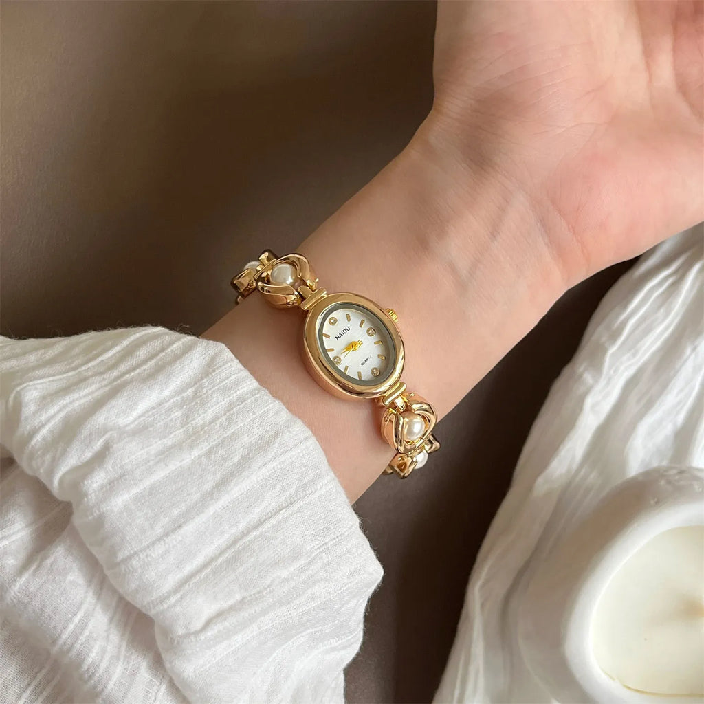 Women's quartz fashion bracelet watch with alloy case and pointer display, gold strap with white surface