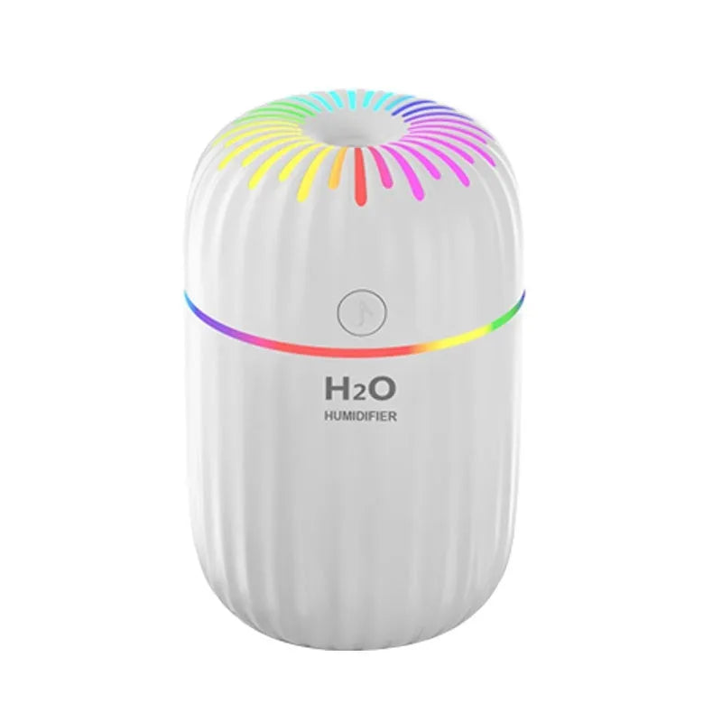 White USB mini humidifier with 300ml tank on a desk next to a laptop.