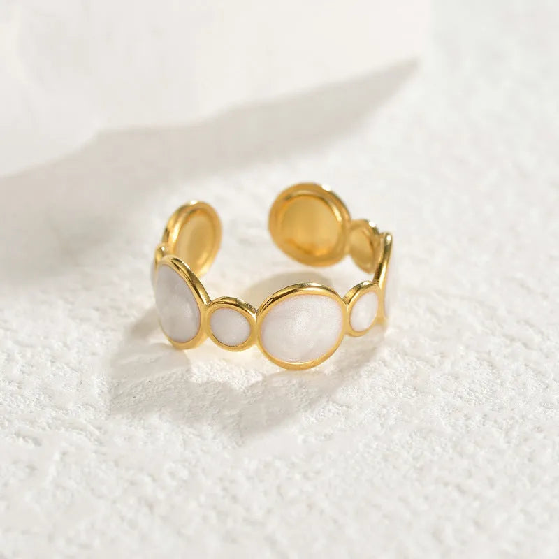 Adjustable geometric ring in stainless steel with a light luxury electroplated finish on a grey background.