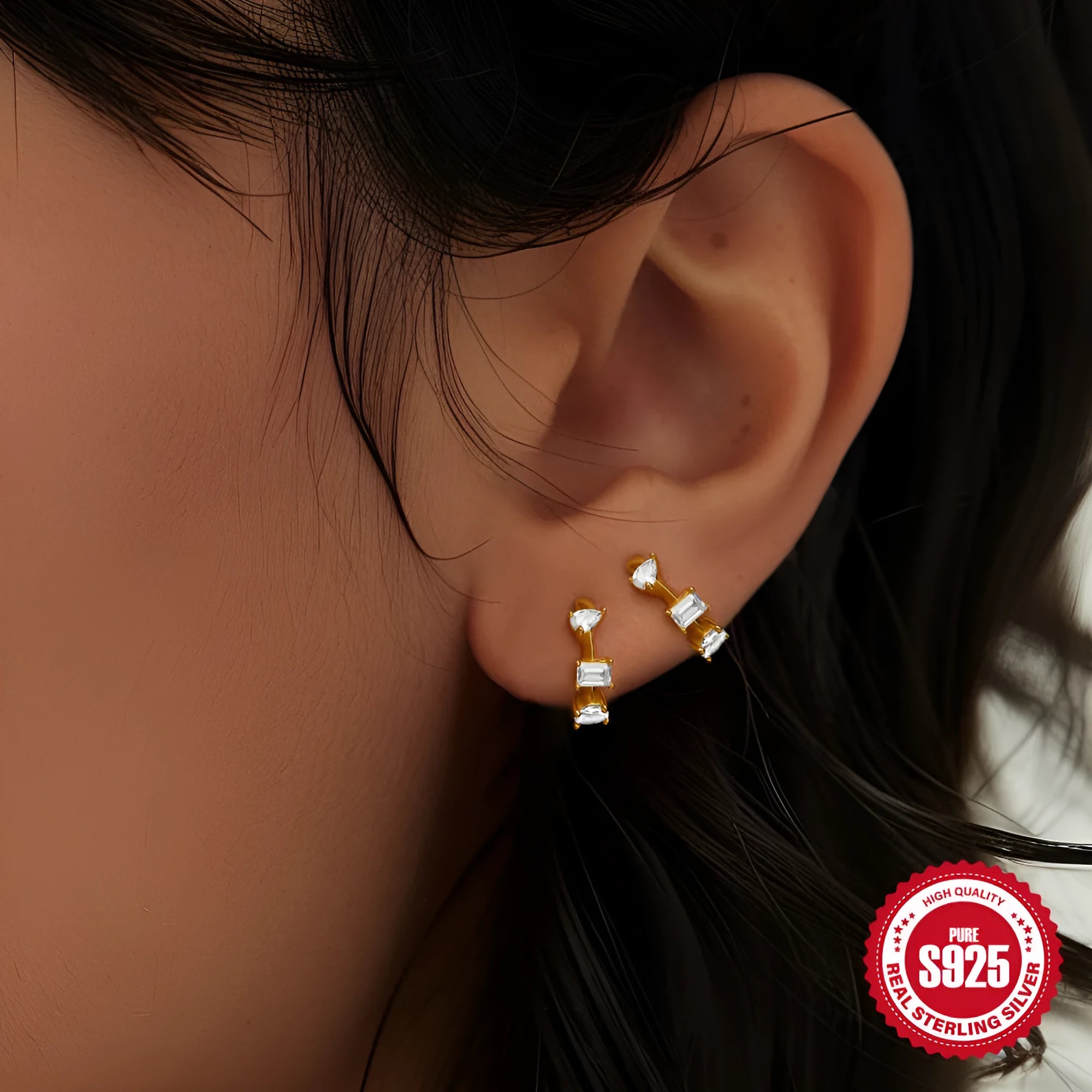 A pair of small round geometric stud earrings in sterling silver with a gold electroplated finish.