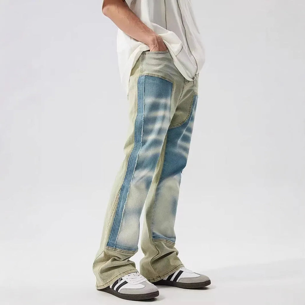 Yellow and blue retro patchwork jeans with a splash-ink damaged design on a mannequin.