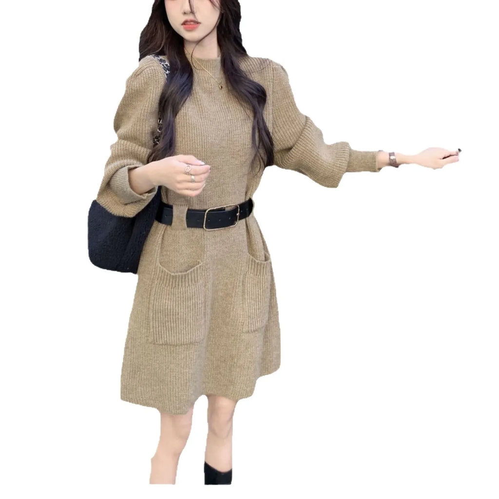 Women's beige long sleeve loose knit dress with a black belt on a hanger.