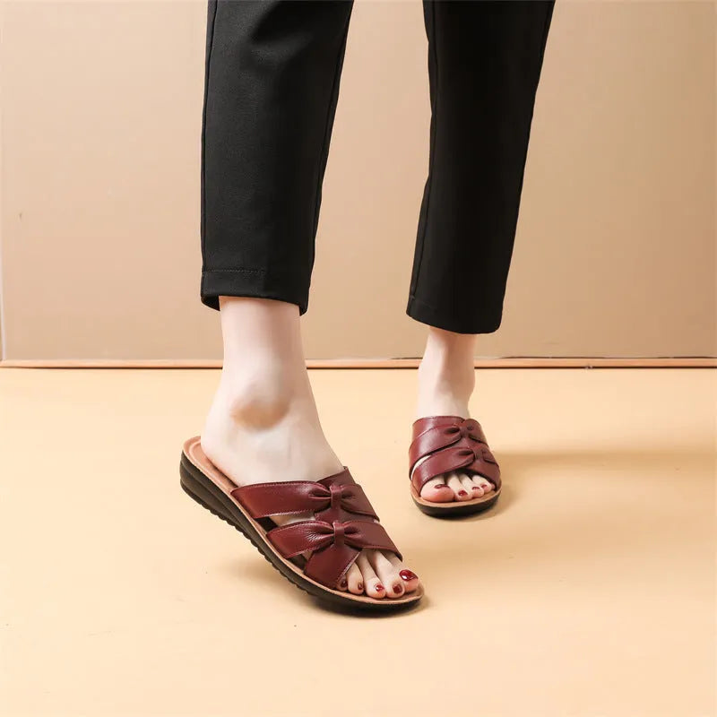Beige cowhide women's slipper sandals with a non-slip sole, shown from the side.