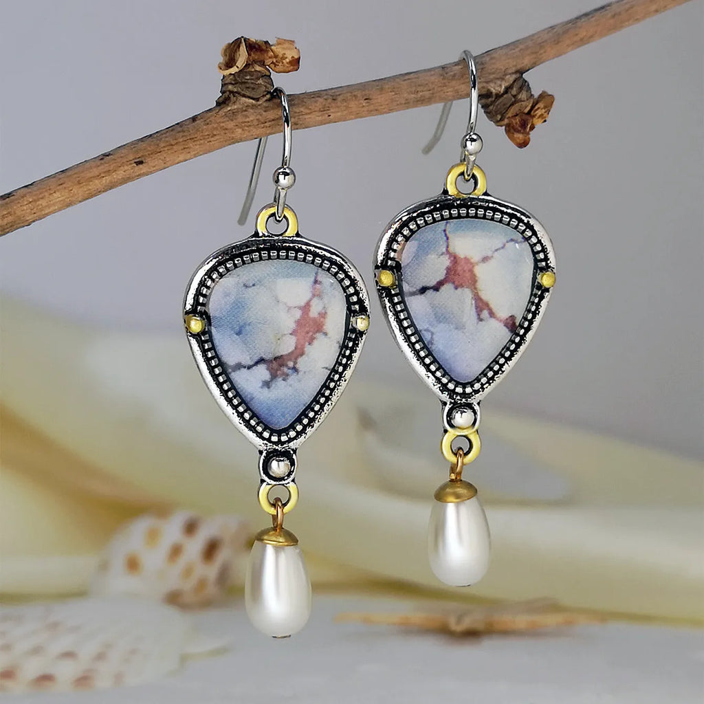 Retro blue drop earrings with synthetic blue opal and white pearl on a geometric metal setting.