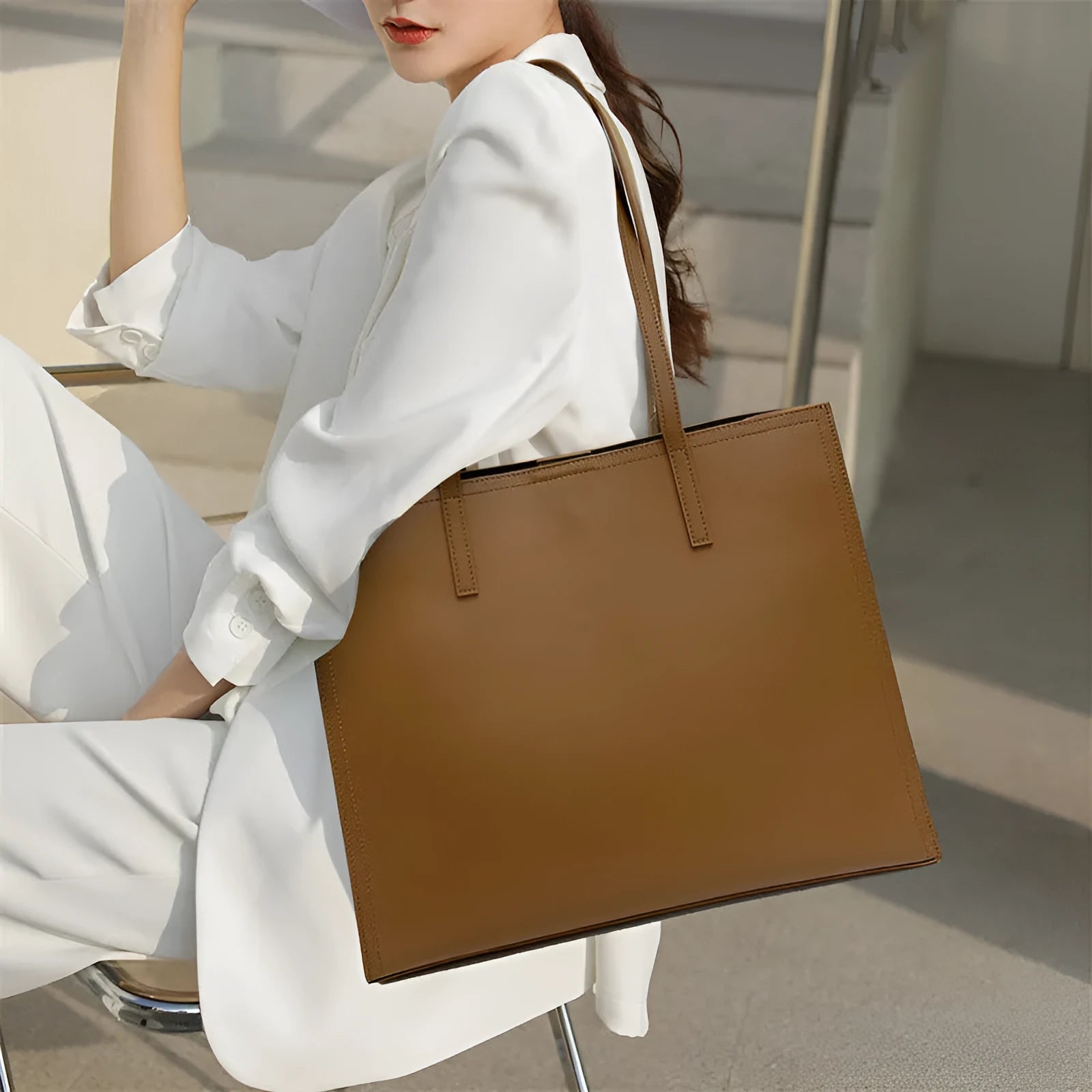 Women's brown genuine leather handbag with multiple internal pockets and single shoulder strap