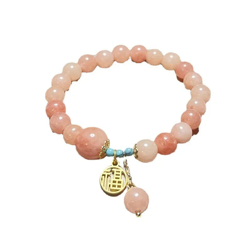 Pink alloy bracelet with natural stone details for women on a simple background.