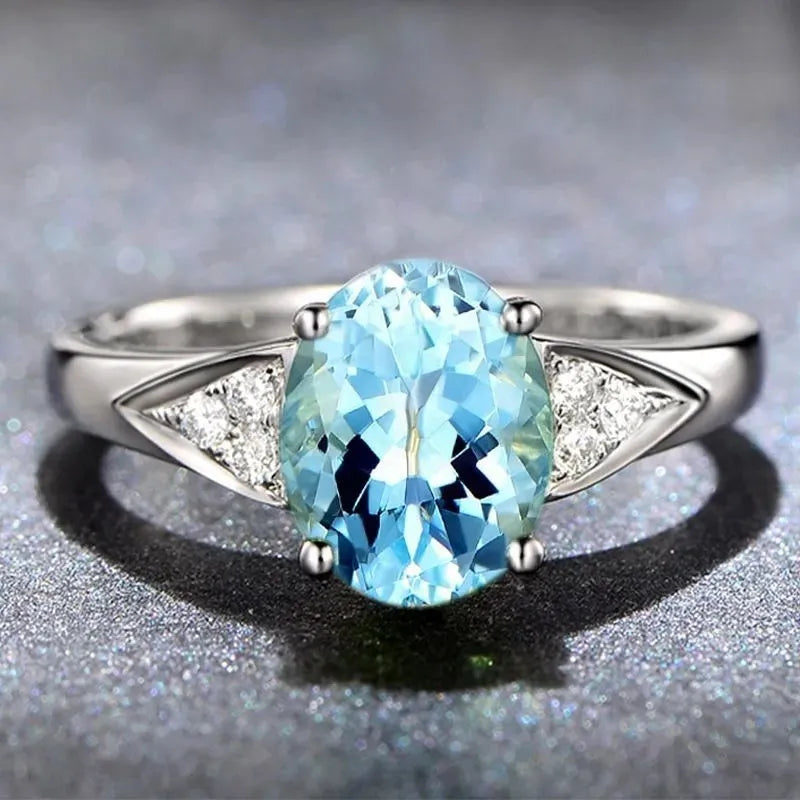 A women's sterling silver ring with a geometric pattern of inlaid red and blue natural zircon stones on a comfort-fit band.