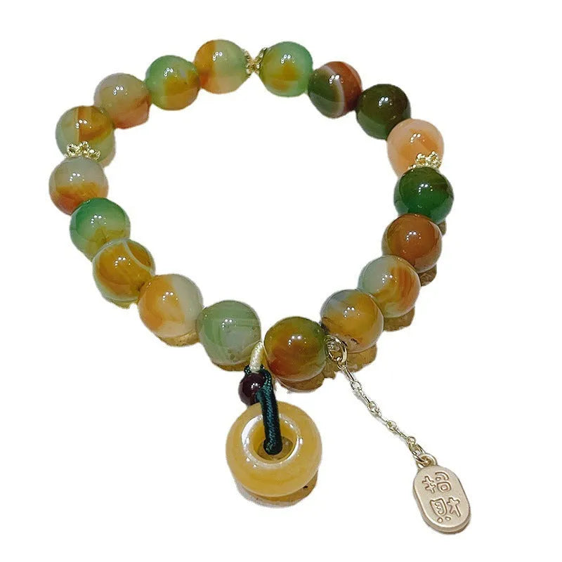 Yellow peacock agate and topaz beaded bracelet with a metal safety chain and peace buckle clasp.
