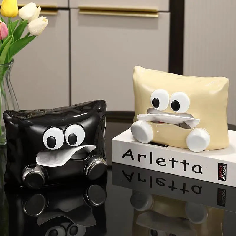 A white ceramic tissue box holder on a wooden coffee table.