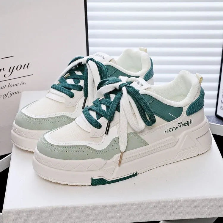 Beige children's platform trainers with cross shoulder straps and white laces on a 3cm thick rubber sole.