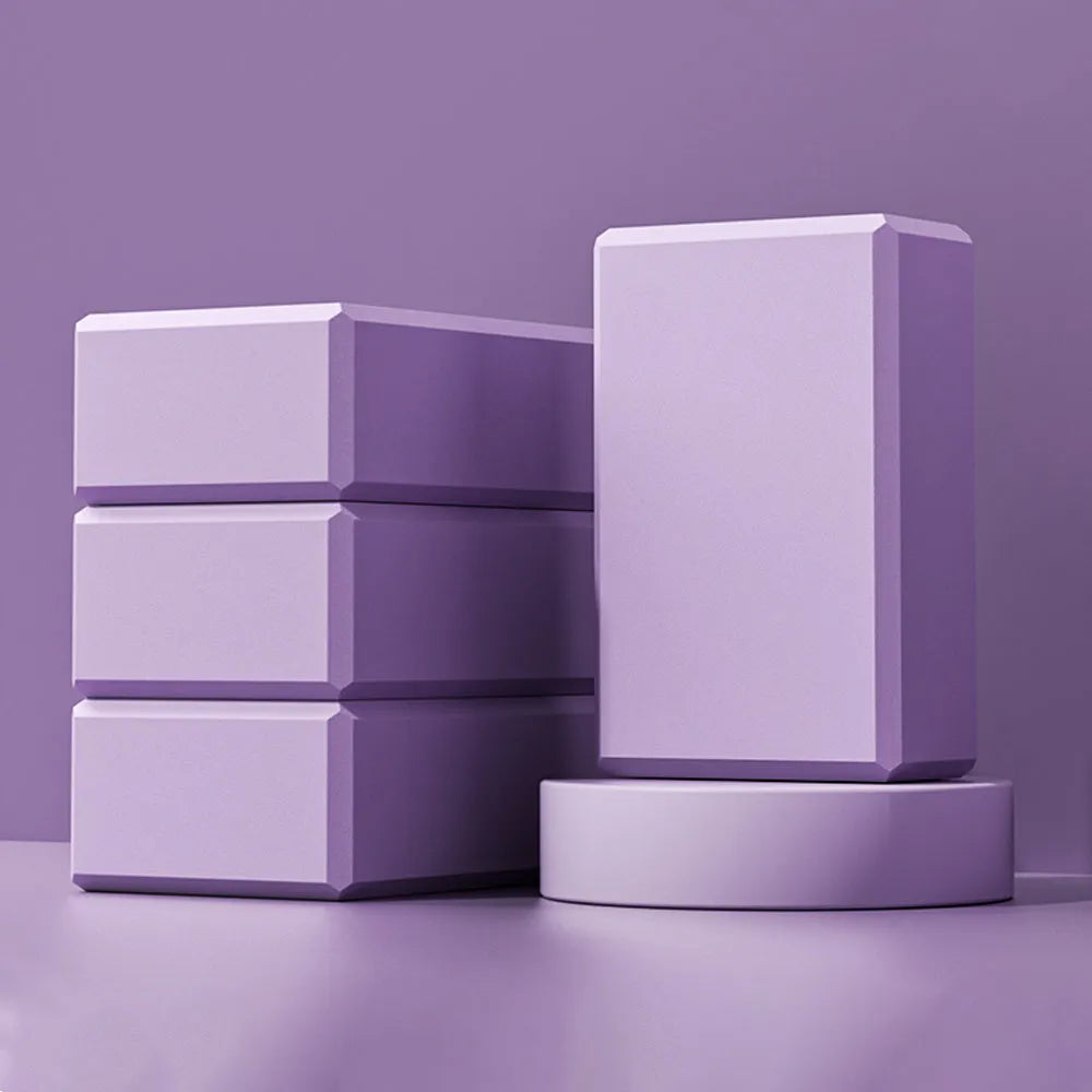 Solid blue EVA foam yoga brick with ridged hexagonal surface, shown next to a pink block.
