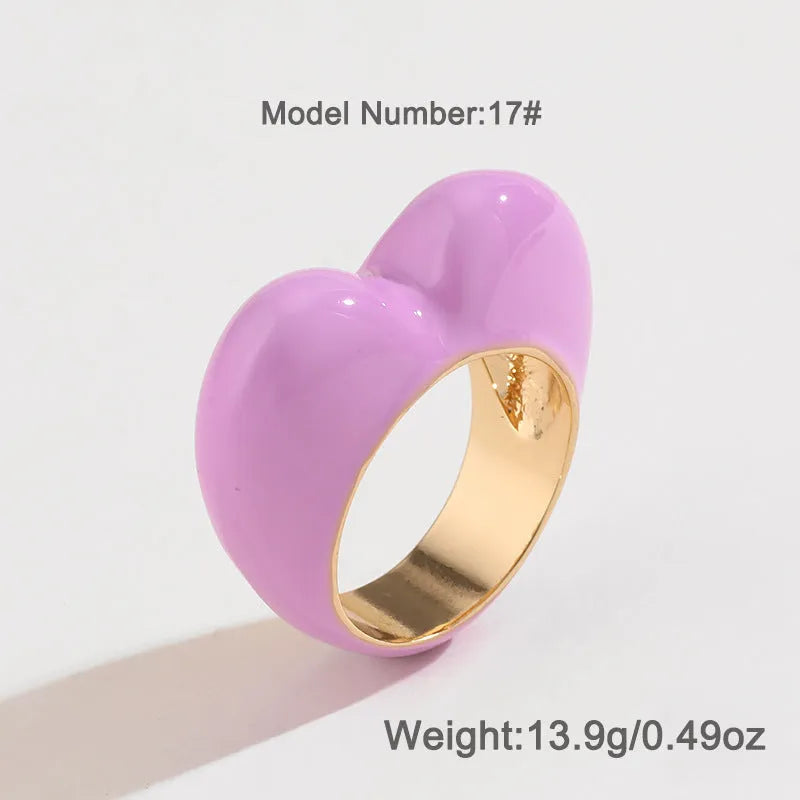 Colourful three-dimensional heart-shaped enamel ring in zinc alloy on a hand.