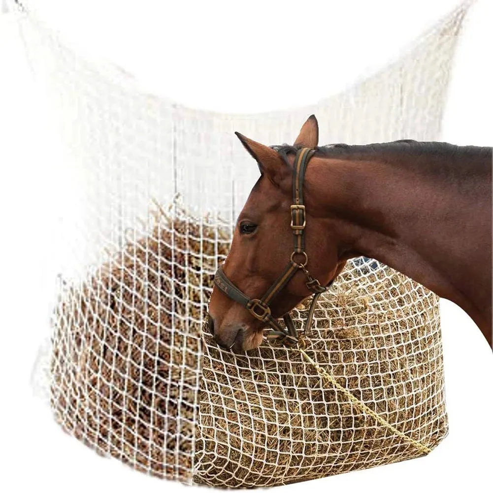 Woven polyethylene rope horse feeding bag in black hanging with hay visible through grid
